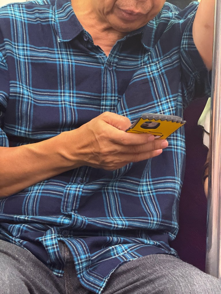 Older dude with a Bart Simpson phone case